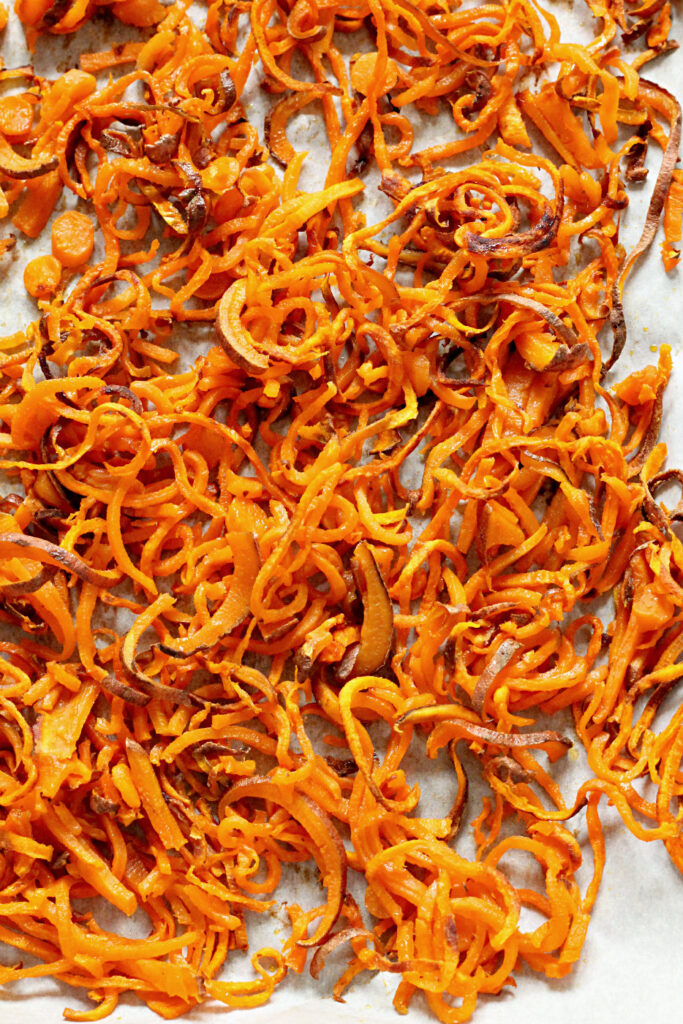 Spiralized Sweet Potato on a baking sheet lined with parchment paper.